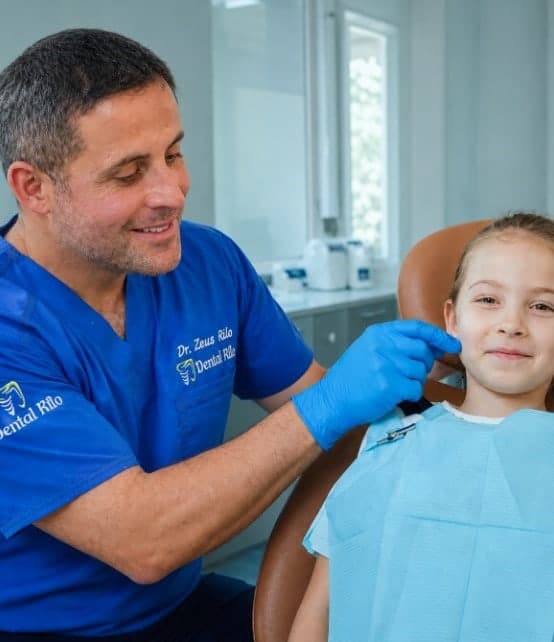 Dr. Zeus Rilo atendiendo a una niña en consulta de odontopediatría, Dental Rilo Lima